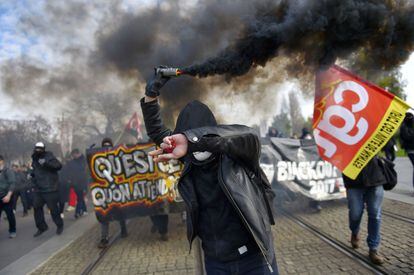 Un manifestante sostiene una bengala durante una protesta contra la reforma laboral de Macron, en Nantes (Francia).