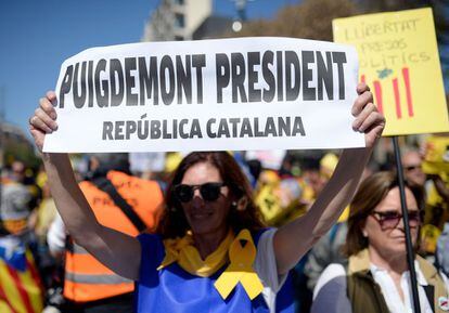 Una mujer sostiene un cartel con donde se lee "Puigdemont presidente. República catalana" durante la manifestación.