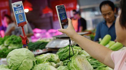 Una clienta escanea un código QR para pagar en un mercado de Pekín, China.
