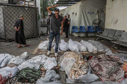 Un palestino grita junto a cadáveres de un ataque israelí frente al hospital Al Najjar de Gaza, el jueves.