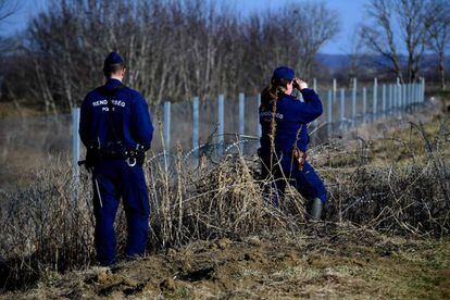 Dos polic&iacute;as patrullan la valla fronteriza entre Hungr&iacute;a y Croacia el 23 de febrero.