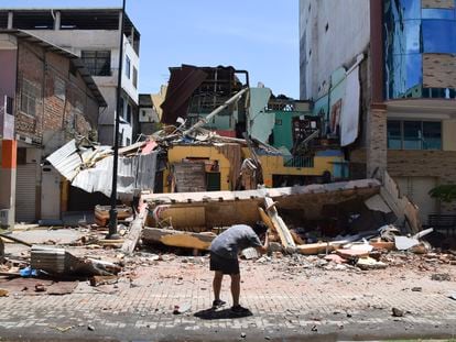 Un hombre saca una fotografía de un edificio derrumbado en Machala (Ecuador), este sábado.