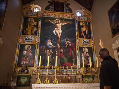 El sacerdote Antonio Fajardo explica el retablo en la iglesia de San Miguel de Guadix (Granada).