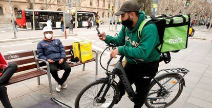 Repartidores de Glovo, Deliveroo y Uber Eats esperando un servicio en Barcelona, en una foto de archivo.