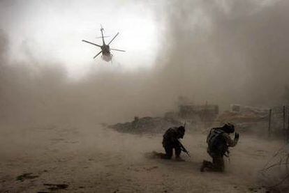 Soldados estadounidenses se protegen de la arena levantada por un helicóptero en Kandahar.