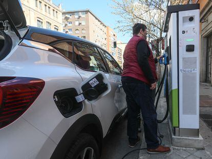 Unos usuarios intentando recargar su vehículo en un punto de recarga de coches eléctricos en Madrid.