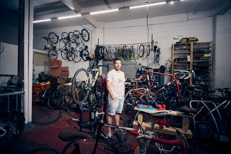 Alejandro Corroto, fundador de MenSos, una empresa de reparto sustentable, en el taller de bicicletas desde donde trabaja.