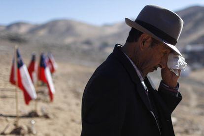 Ramón Ávalo, de 81 años, se seca las lágrimas al ver las banderas con los nombres de sus dos nietos, atrapados en la mina San José.