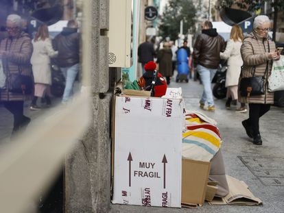 Una persona sin hogar se resguarda del frío con cartones en Madrid.