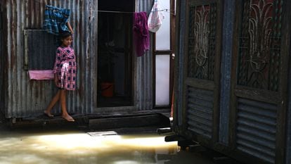 Una niña ante la puerta de su casa, inundada por las fuertes lluvias, en el distrito de Munshiganj, a las afueras de Daca, en julio de 2020