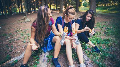 Un grupo de chicas comen durante una ruta de senderismo.