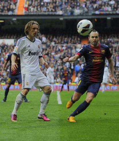 Iniesta y Modric pugnan por el bal&oacute;n.