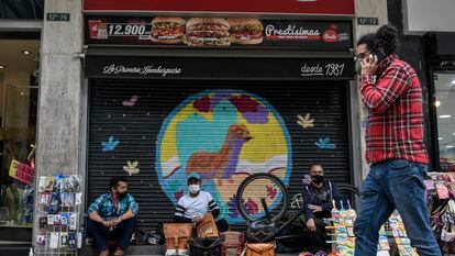 Artesanos y vendedores informales se sientan en un restaurante que tuvo que cerrar y quebró, en Bogotá, el 02 de julio de 2020.