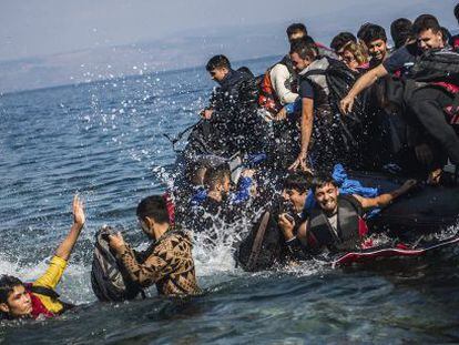 Migrantes saltan de una lancha neum&aacute;tica tras lograr alcanzar la costa cerca de Skala Sikaminias, en la isla griega de Lesbos.
