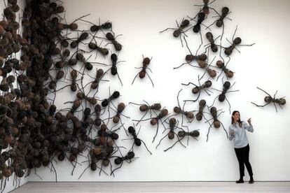 Una visitante posa junto a la obra 'Casa Tomada', de Rafael Gomezbarros, en la muestra 'Pangaea: Arte Nuevo de África y América Latina' en la galería Saatchi de Londres.