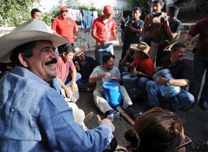 El presidente depuesto de Honduras Manuel Zelaya escucha a un grupo del Frente Nacional de la Restistencia tocando música en la Embajada brasileña de Tegucigalpa, donde permanece recluido.