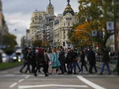 Peatones cruzando un semáforo de la Gran Vía de Madrid.