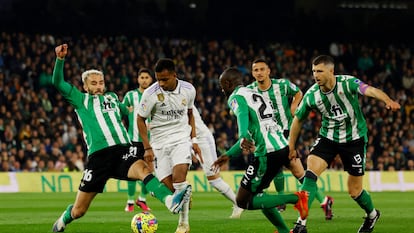 Rodrygo trata de internarse en el área del Betis ante la presión de varios jugadores verdiblancos.