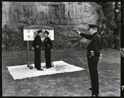Dos agentes bromean en el campo de tiro de la Policía de los Ángeles, mientras un tercer uniformado simula que va a dispararles.
