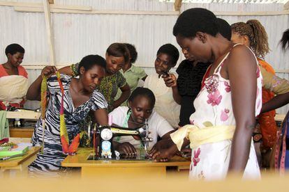 Annociatta enseña a las alumnas el uso de la máquina de coser. 
