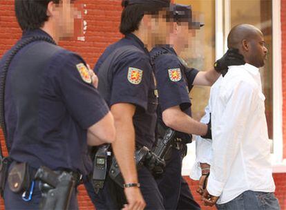 La policía trasladaba ayer a uno de los detenidos durante la operación desarrollada en Málaga.