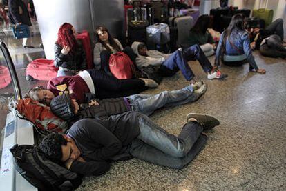Varias personas duermen sobre el suelo del aeropuerto Jorge Newbery de Buenos Aires.