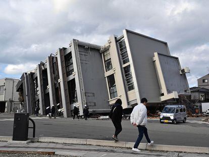 Varias personas pasan junto a un edificio dañado por el terremoto en la ciudad de Wajima (prefectura de Ishikawa), el 4 de enero.