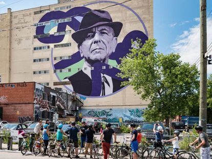 Ciclistas urbanos ante un retrato de Leonard Cohen en una medianera de Montreal, ciudad natal del cantante canadiense.