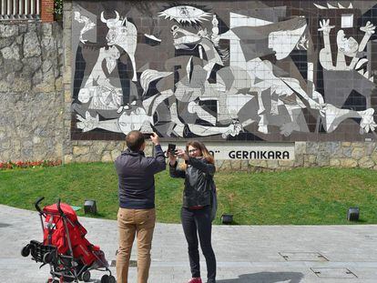 Una pareja toma una foto de una réplica del 'Guernica' de Picasso.