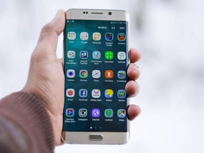 Un usuario sostiene un 'smartphone' con múltiples aplicaciones.