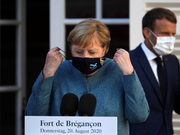 German Chancellor Angela Merkel wears a face mask as she arrives with French President Emmanuel Macron for a press conference after a meeting at Fort de Bregancon, in Bormes-les-Mimosas, France, on August 20, 2020. Christophe Simon/Pool via REUTERS