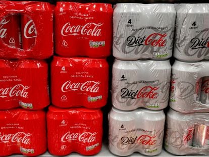Latas de Coca-Cola y Coca-Cola Light apiladas en un supermercado.
