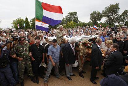 Banderas de Suráfrica en la época del apartheid y de la ex república bóer de Transvaal reciben el féretro de Eugène Terreblanche. El fundador del Movimiento de la Resistencia Afrikáner ha sido enterrado hoy en Ventersdorp (noroeste del país) ante la presencia de miles de seguidores.