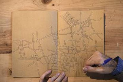 Fernández dibuja un mapa en su cuaderno.
