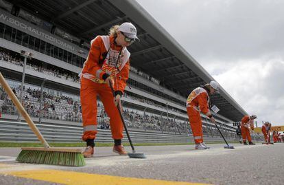 Trabajadores preparan la pista antes de la carrera.