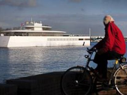 Un hombre que pedalea en su bicicleta observa como el yate ordenado construir por el cofundador de Apple Steve Jobs, compite en una regata cerca de Velsen, Holanda. EFE/Archivo