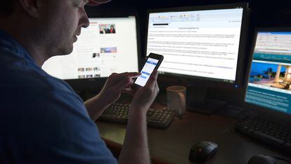 Un hombre revisa internet y sus redes sociales en un móvil y otras pantallas.