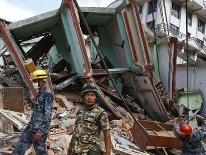 Miembros de los servicios de rescate buscan supervivientes entre los escombros, este martes en Katmandú.