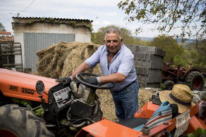 Pedro, vecino de un núcleo rural de A Teixeira, posa apoyado en su tractor.