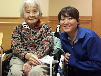 Una mujer japonesa de avanzada edad, junto a una cuidadora y el robot 'Sota', en una residencia de Tokio.