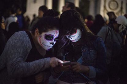 Dos mujeres caracterizadas como catrinas en la Ciudad de México.