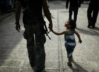 Un miliciano de las Brigadas de los Mártires de Al Aqsa camina con su hija en una calle de la ciudad cisjordana de Nablus.