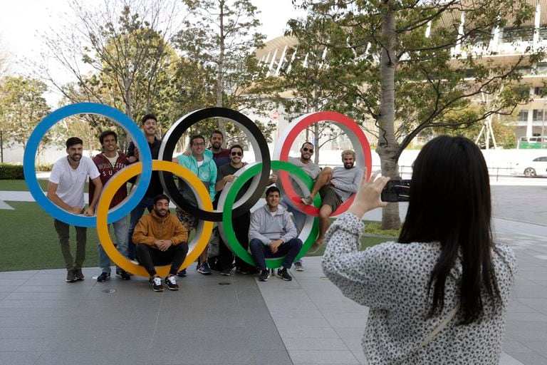 Un grupo de estudiantes uruguayos posan junto a los anillos olímpicos en las afueras del estadio de Tokio (Japón).