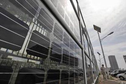 Un trabajador camina junto a una pared de fotovoltaica de aislamiento en los alrededores de la compañía Yingli Green Energy Holdings Co en Baoding (China). Pekín anunció que permitirá la entrada de capital privado en la financiación de proyectos que hasta ahora estaban monopolizados por el Estado, como las energías renovables, la construcción de oleoductos y gasoductos, infraestructuras de transporte, carbón o industrias químicas y petroquímicas. EFE/Archivo