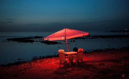 Una mesa y unas sillas de plástico junto al mar, en Trípoli, Líbano.