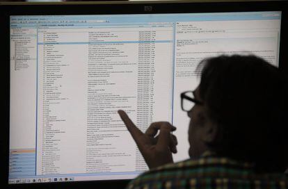 Un hombre consulta su correo electrónico en un ordenador en su puesto de trabajo.