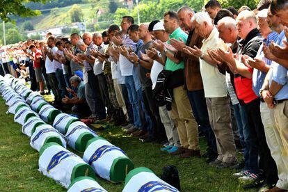 Musulmanes bosnios rezan frente a los cuerpos de 33 hombres recientemente identificados como víctimas de Srebrenica, el pasado 11 de julio de 2019.