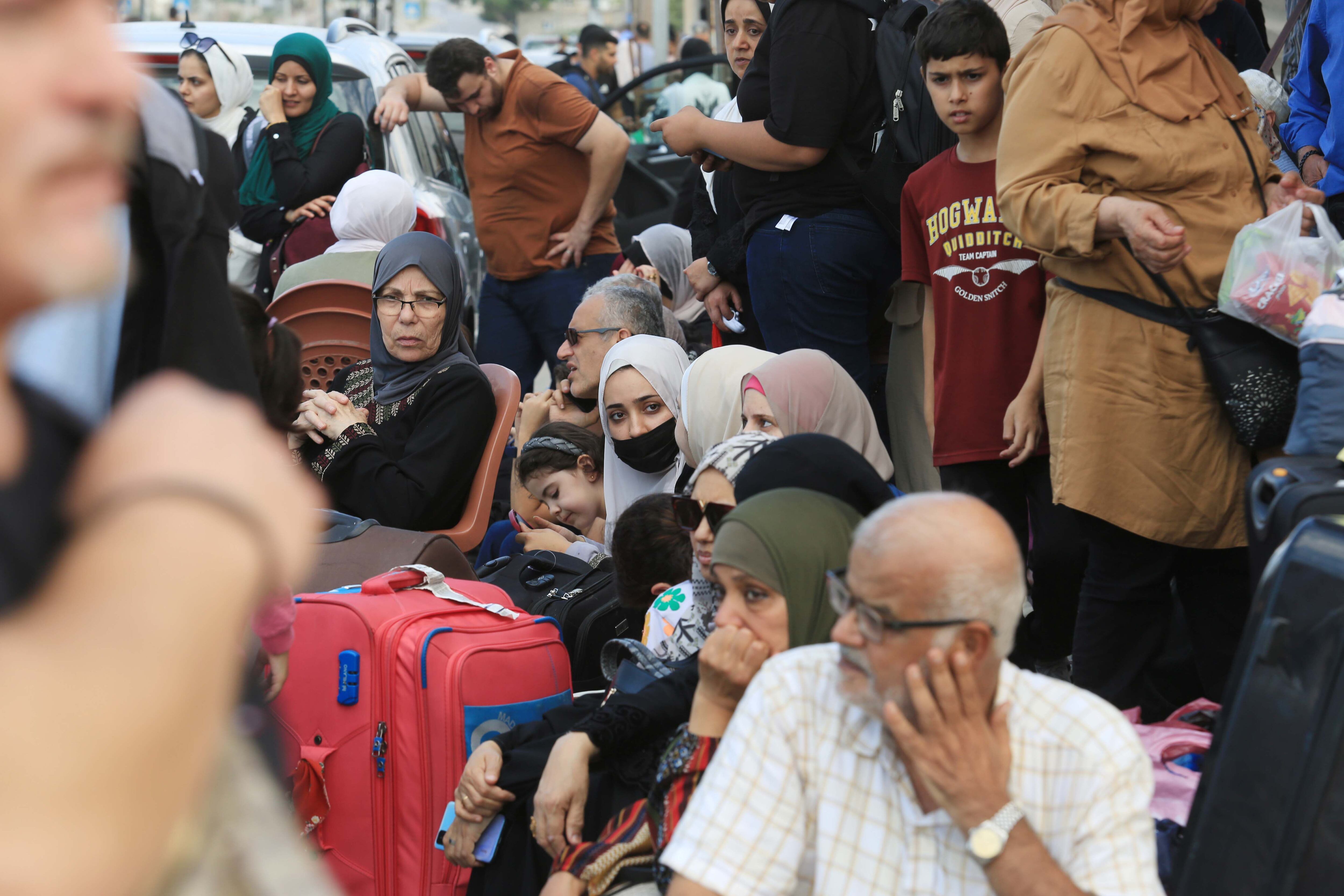 Un grupo de palestinos, cerca del paso de Rafah en espera de poder escapar de Gaza a Egipto.