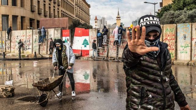 Varios manifestantes intentan traspasar el 11 de febrero los muros de hormigón levantados para impedir el acceso de civiles al Parlamento libanés en Beirut.