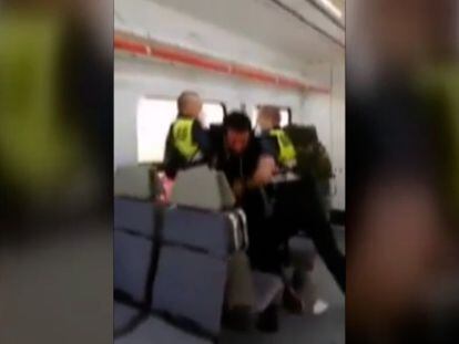 Dos vigilantes de seguridad forcejean violentamente con un pasajero en Cataluña.